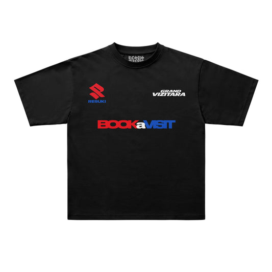A black short-sleeve t-shirt with multiple graphic prints. The chest features a large 'BOCKaVISIT' logo in red and blue, with a smaller red and blue 'RESURI' logo on the left chest and a white 'GIANG VIZITARA' print on the right chest.