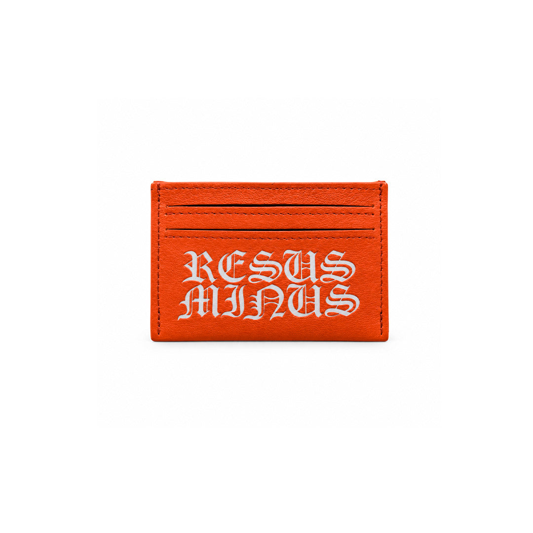A bright orange leather card holder with the phrase 'RESUS MINUS' embroidered in white gothic lettering, shown against a plain white background.