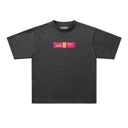 A black short-sleeve t-shirt with a colorful graphic on the chest, displayed flat against a light gray background. The graphic features a pink and yellow block with the text 'RISKO' and 'UNLATER'.
