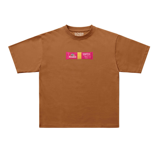 A brown short-sleeve t-shirt with a small graphic on the chest featuring two pink rectangular logos that read 'RISKO' and 'SLATTER'. The t-shirt is displayed flat against a clean, off-white background.