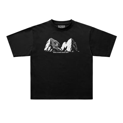 A black short-sleeve t-shirt with a white graphic of two mountain peaks and the text 'RESUS STONED WORKS DEPT' printed on the chest, displayed flat against a light gray background.