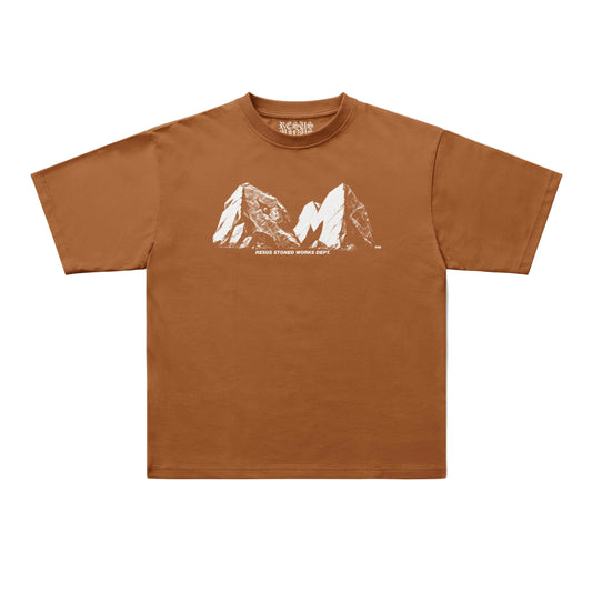 A brown short-sleeve t-shirt with a white graphic of two mountain peaks and the text 'RESUS STONED WORKS DEPT.' printed on the chest, displayed flat against a light gray background.