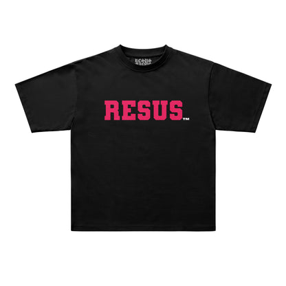 A black short-sleeve t-shirt with the word 'RESUS' printed across the chest in a textured pink font, accompanied by a small white trademark symbol. The shirt is displayed flat against a light gray background.