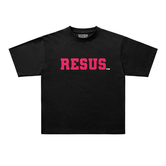 A black short-sleeve t-shirt with the word 'RESUS' printed across the chest in a textured pink font, accompanied by a small white trademark symbol. The shirt is displayed flat against a light gray background.